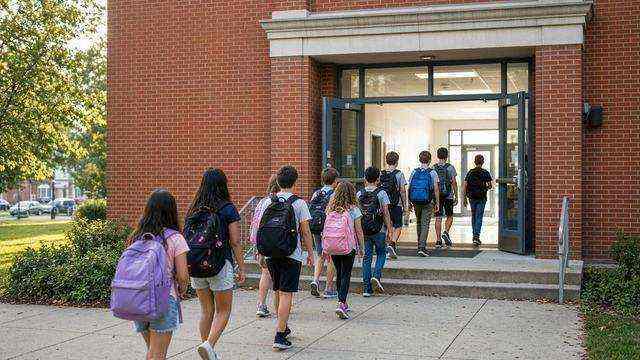 Maryland students entering a public school building in the morning